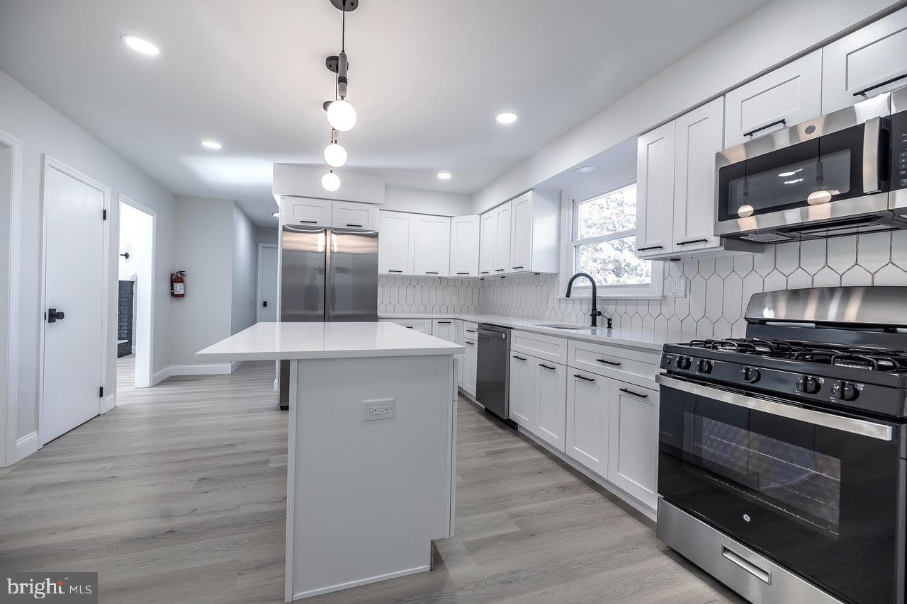 a kitchen with stainless steel appliances a stove sink microwave and cabinets