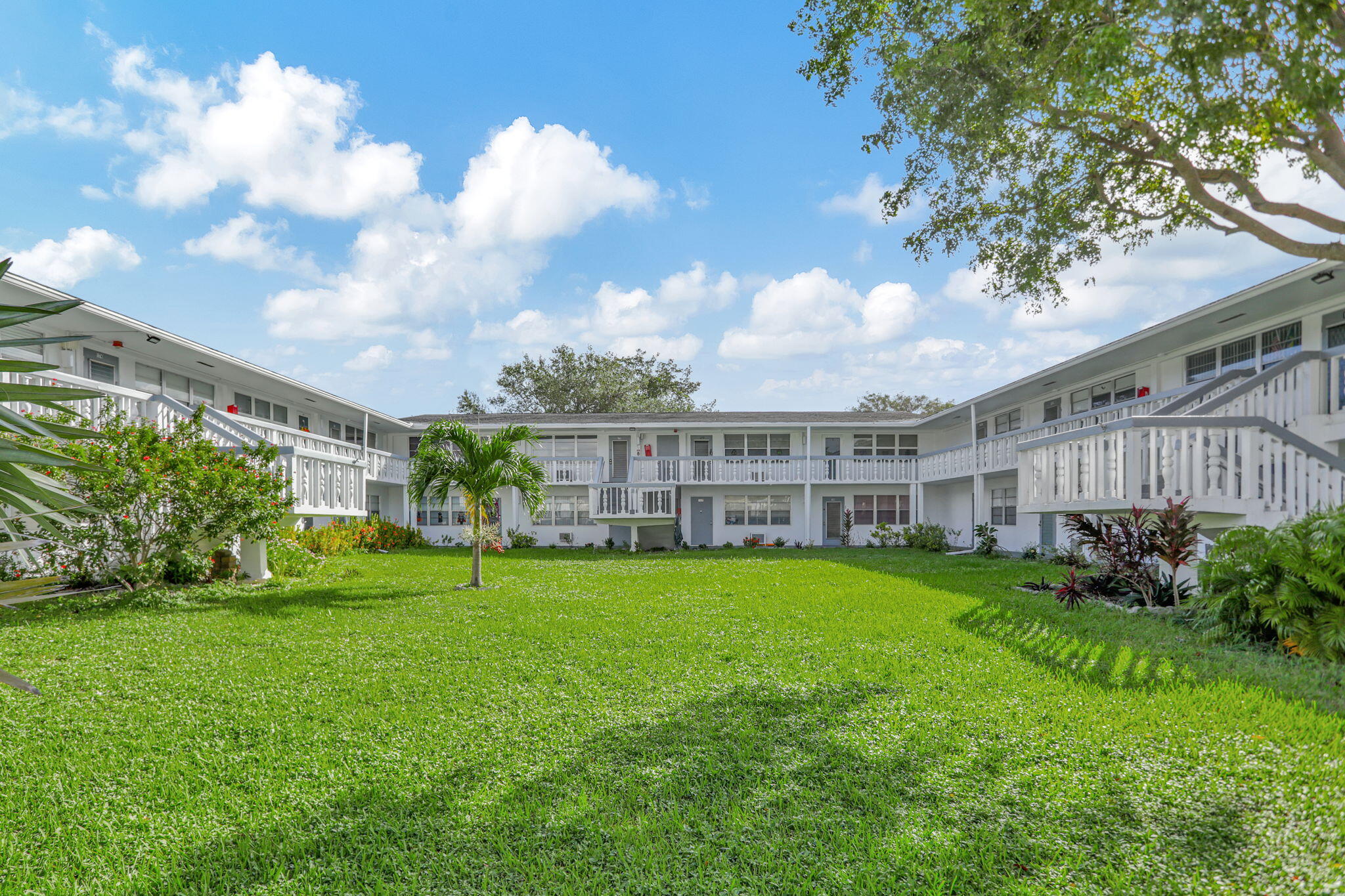 a view of a house with a big yard plants and large trees