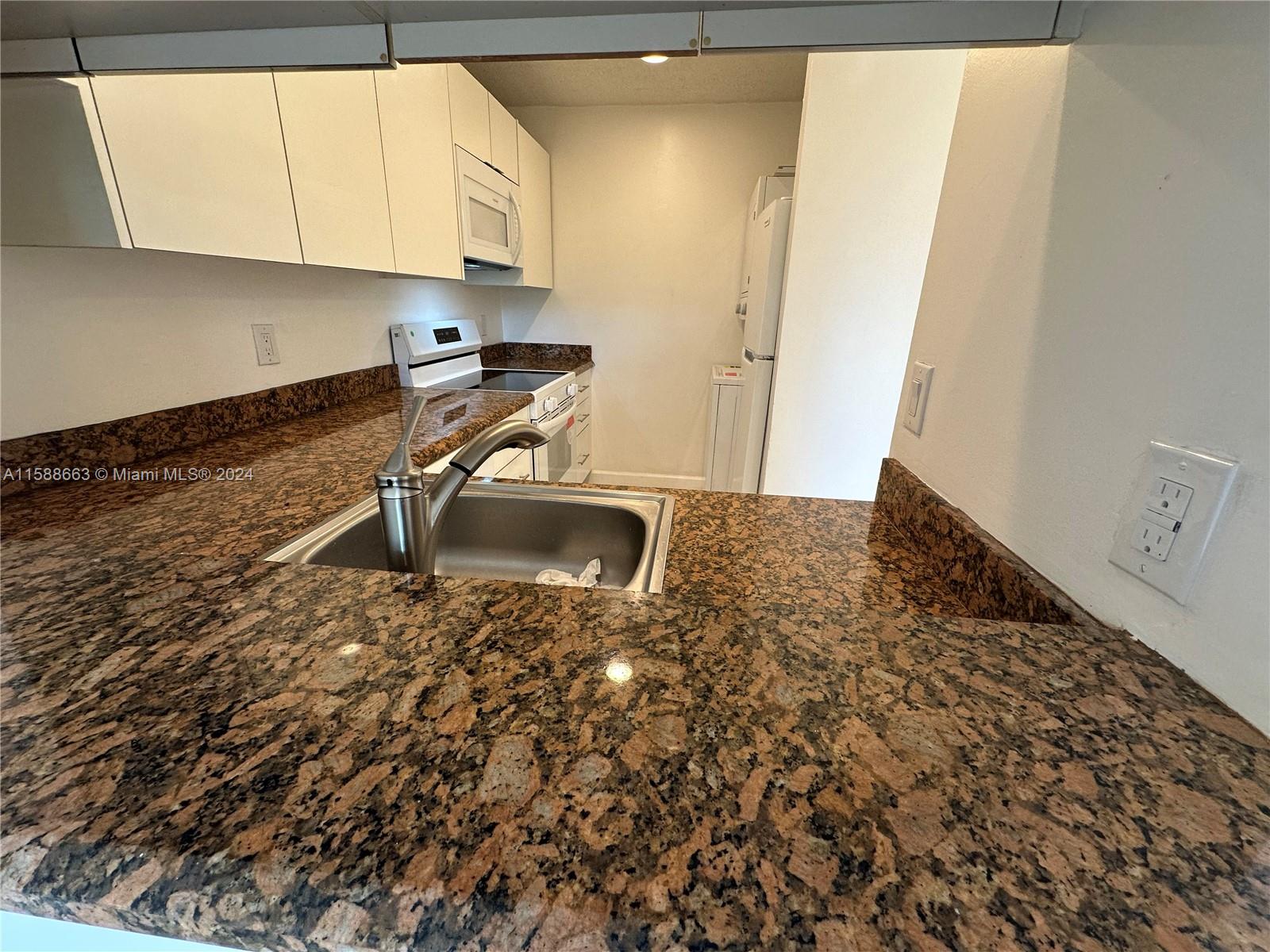 a kitchen with a sink a stove and cabinets