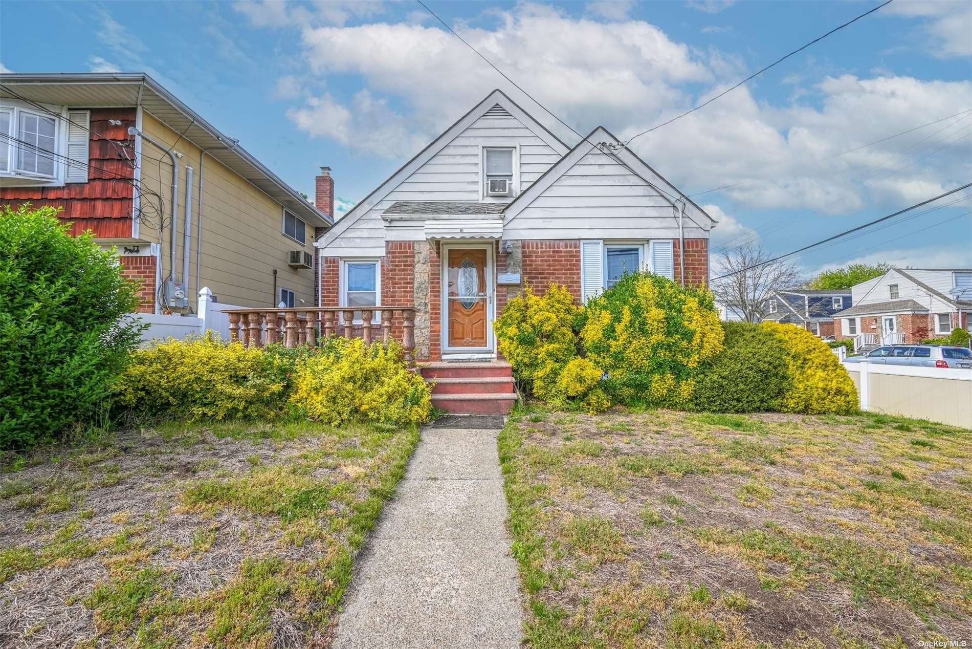 a front view of a house with a yard and potted plants