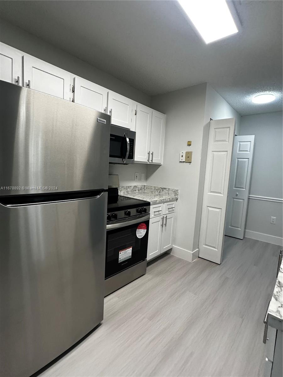 a kitchen with stainless steel appliances a refrigerator and cabinets