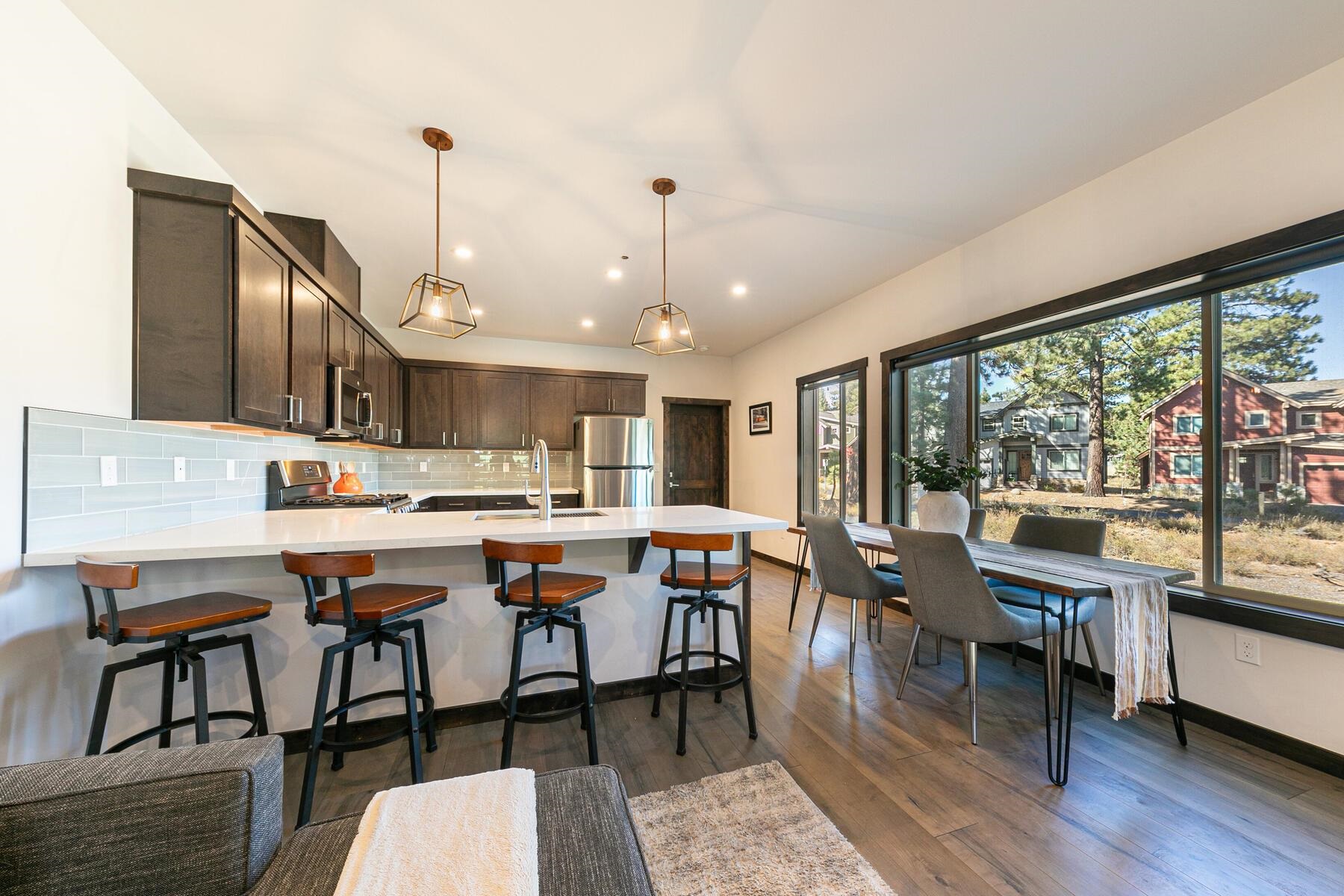 a open dining room with stainless steel appliances granite countertop a stove kitchen island dining table and chairs