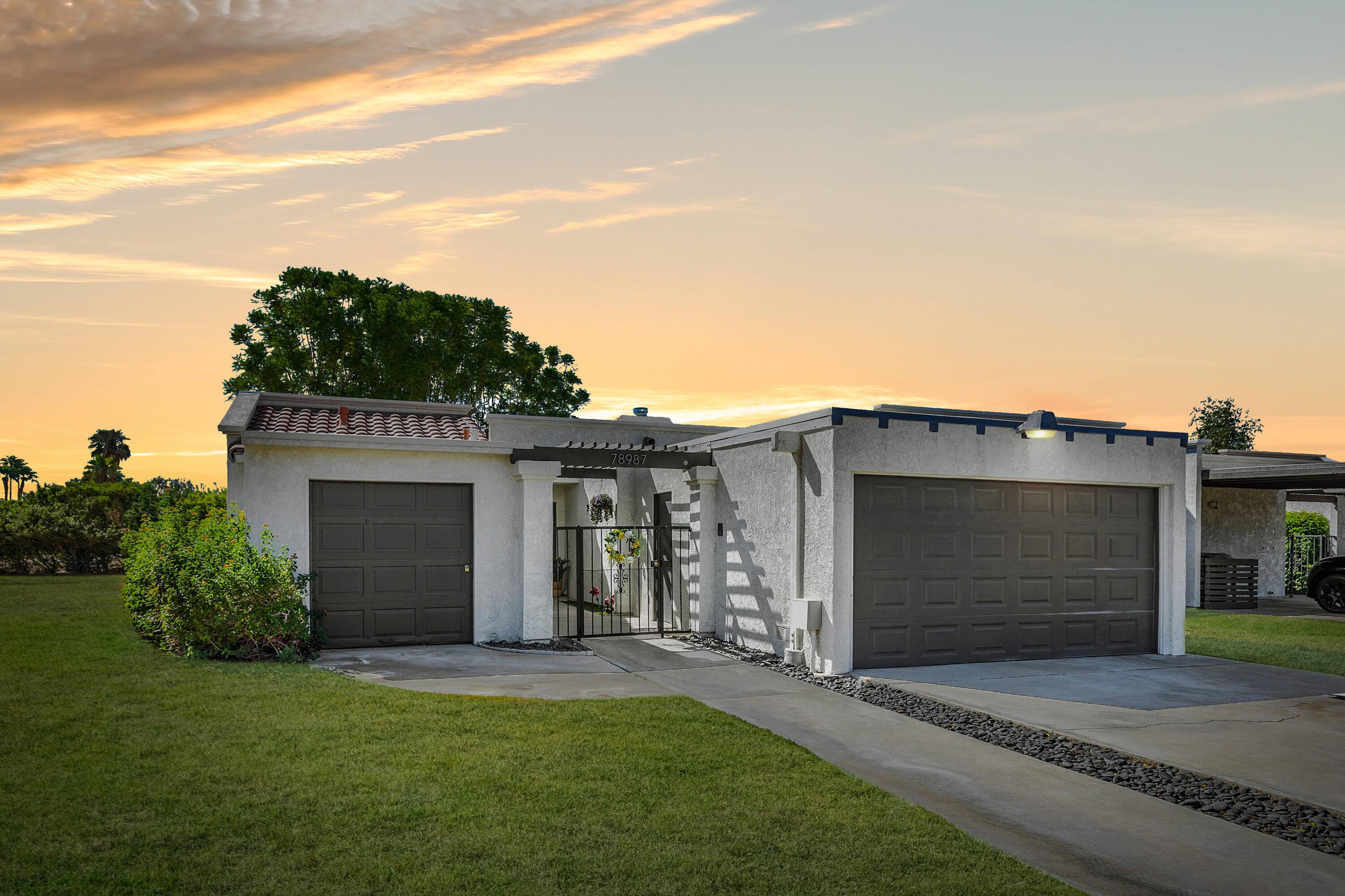 a front view of a house with a garden and garage