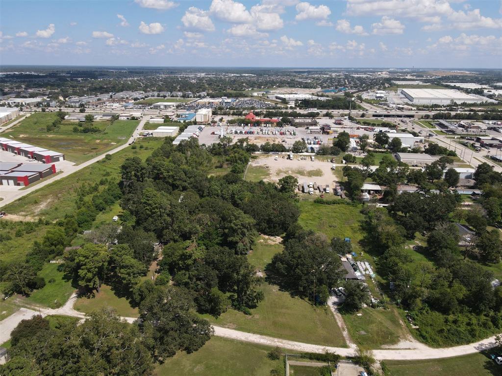 an aerial view of residential houses with outdoor space and trees