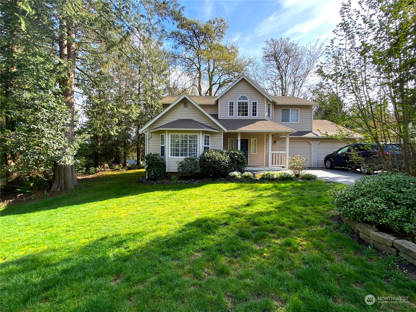 a front view of a house with a yard and trees