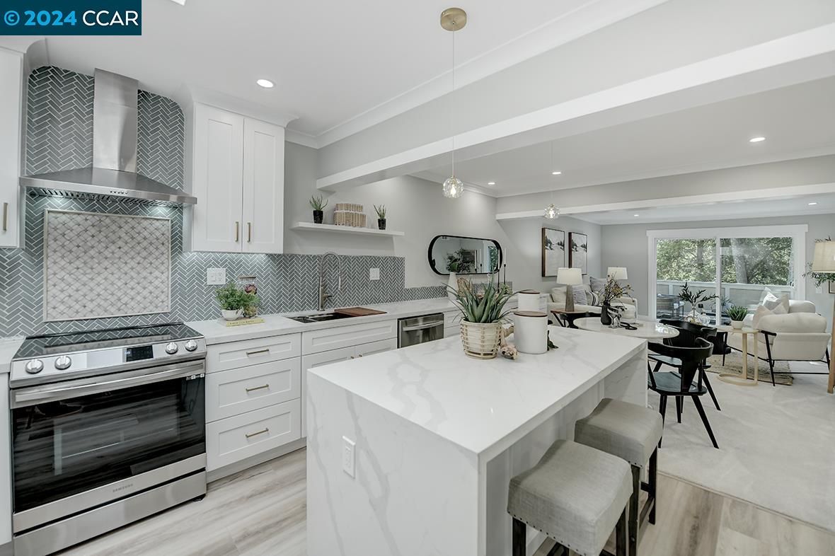 a kitchen with a stove a sink cabinets and wooden floor