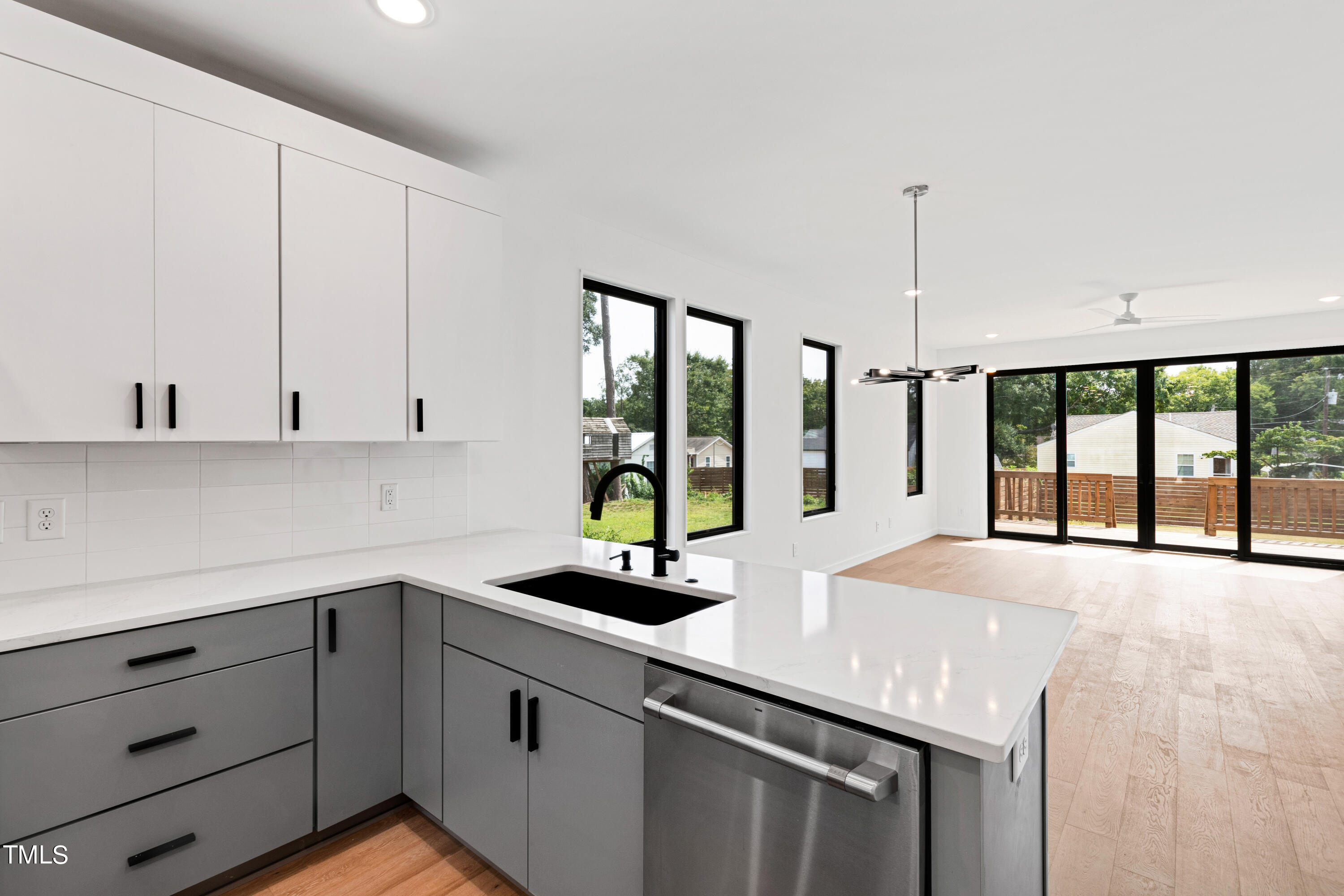 a kitchen with stainless steel appliances a sink a counter and a large window