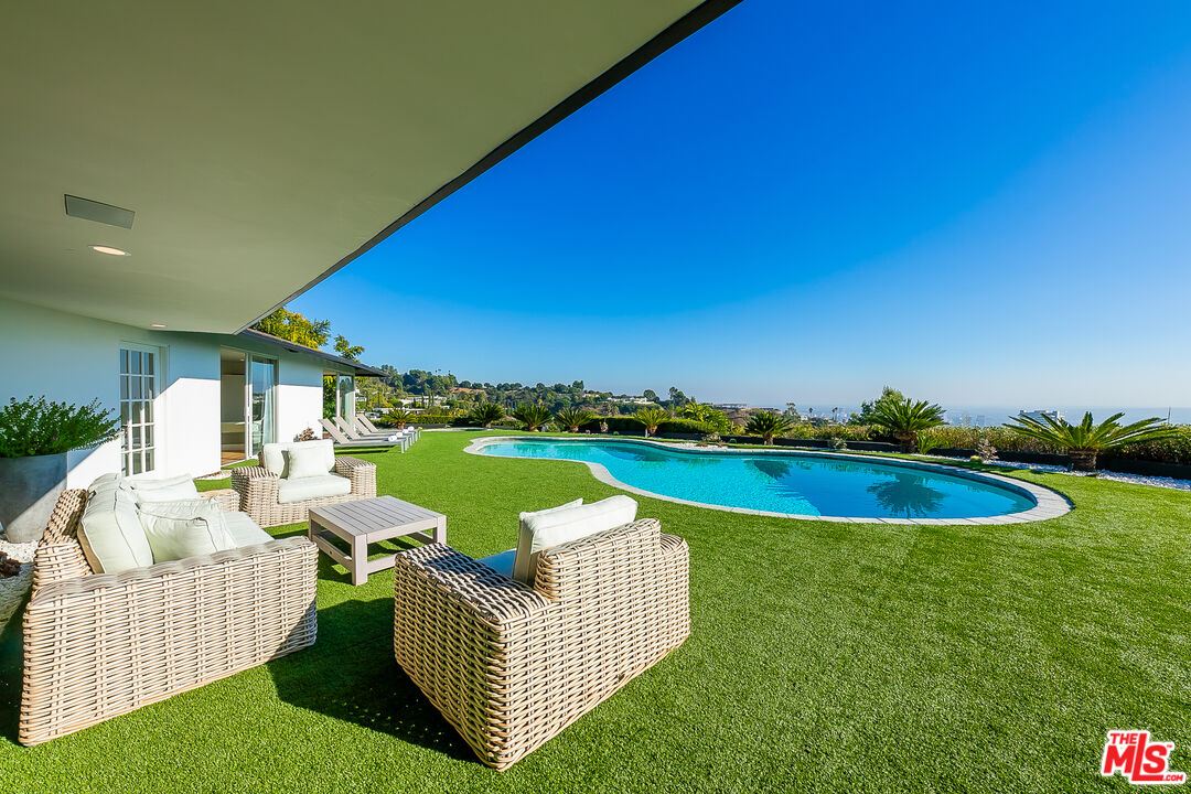 a view of a house with swimming pool and furniture