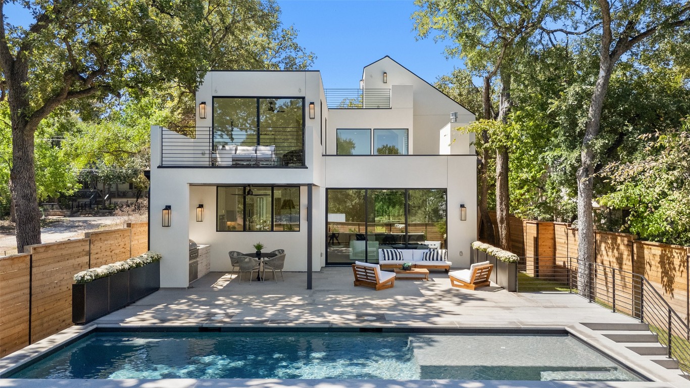 a view of house with swimming pool and glass windows