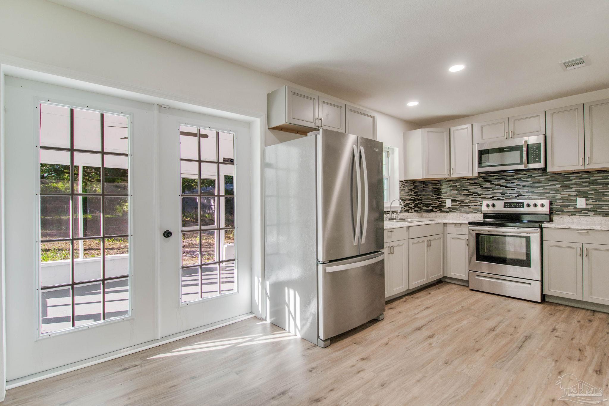 a kitchen with stainless steel appliances a refrigerator sink and cabinets