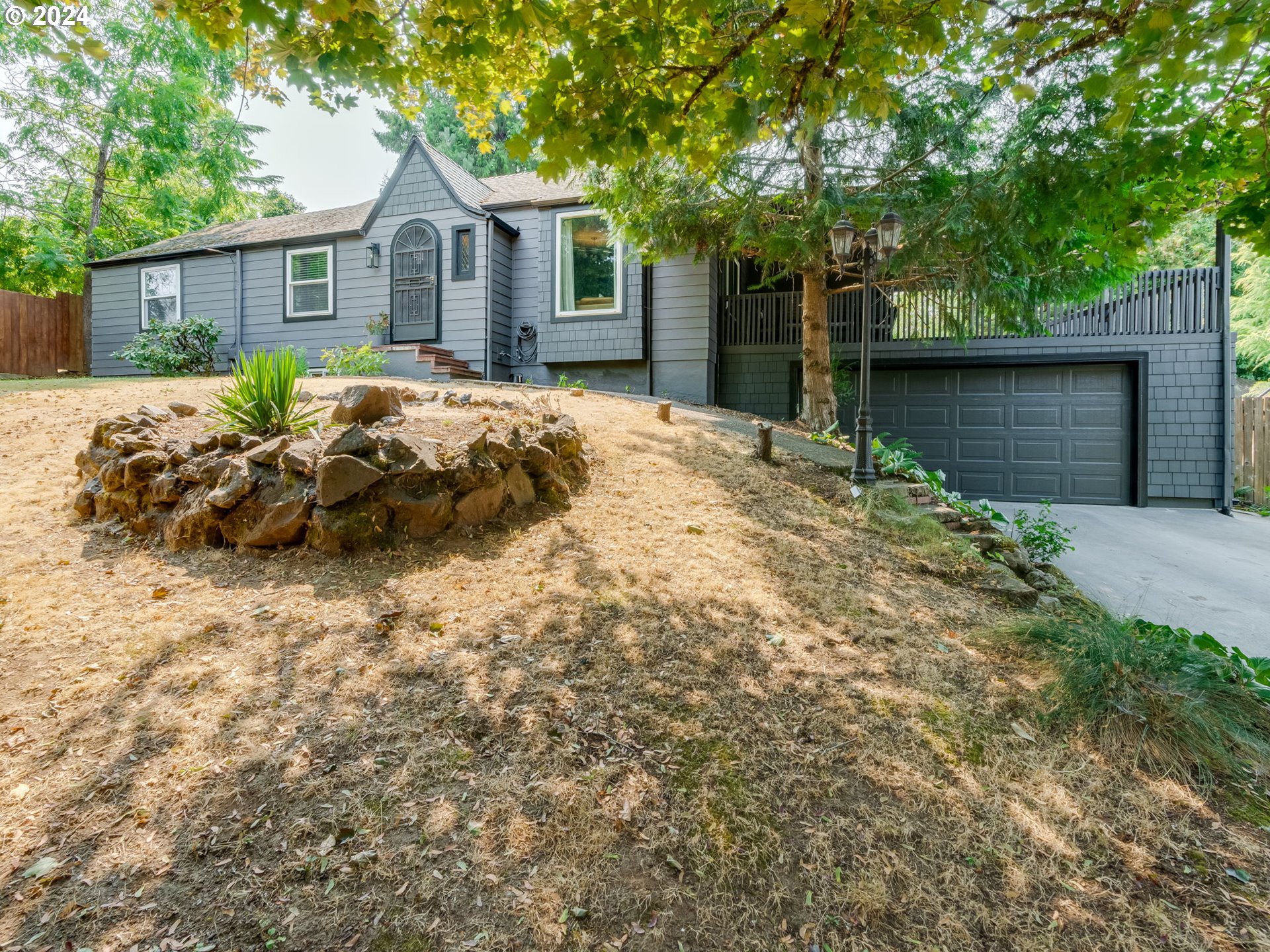 a front view of a house with a garden and yard