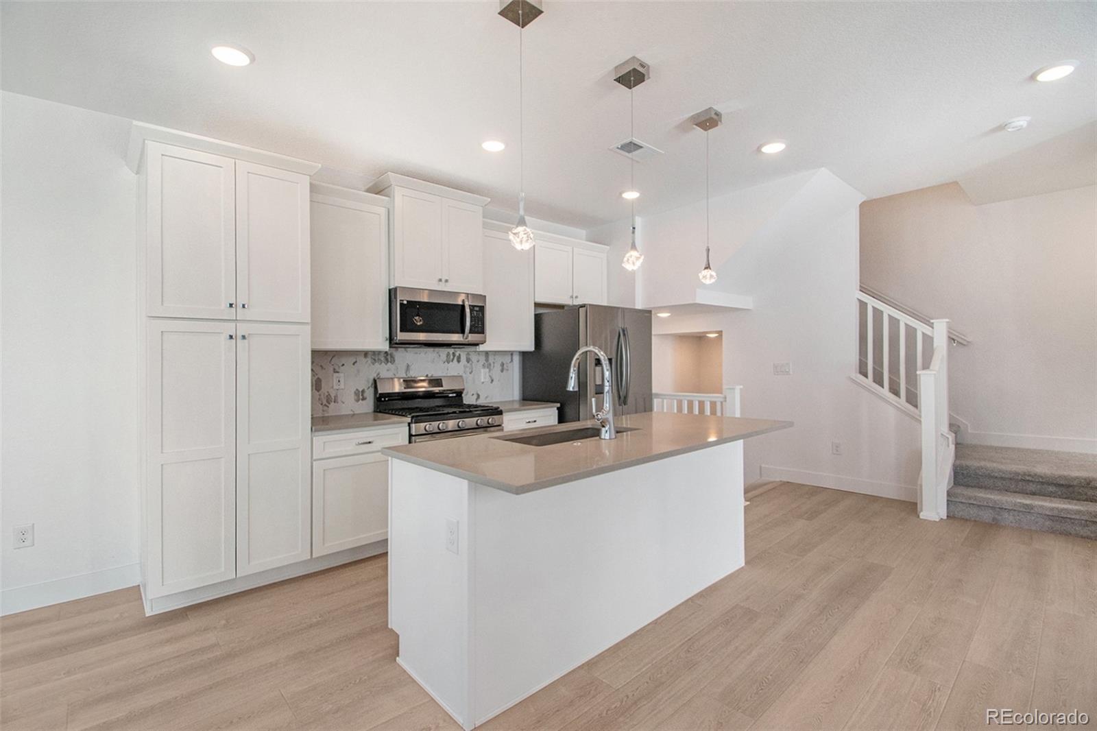 a kitchen with stainless steel appliances a refrigerator and a stove top oven