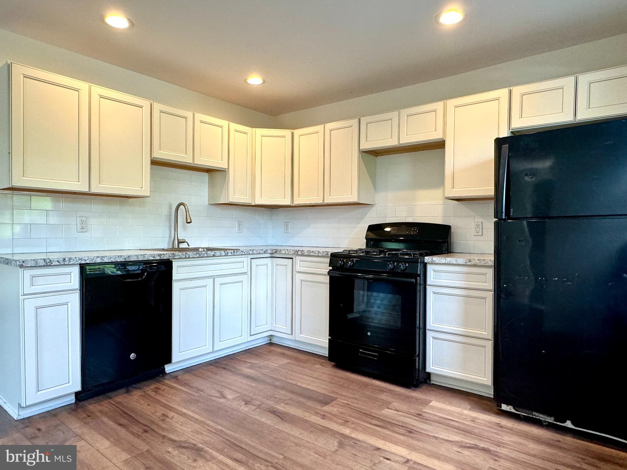 a kitchen with a refrigerator stove and white cabinets