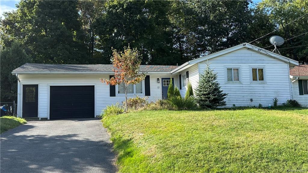 a front view of a house with yard and garage