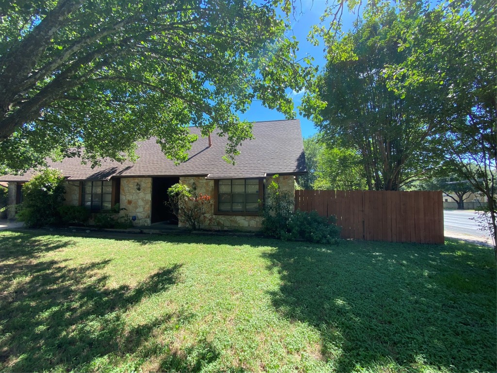 a front view of a house with yard and tree