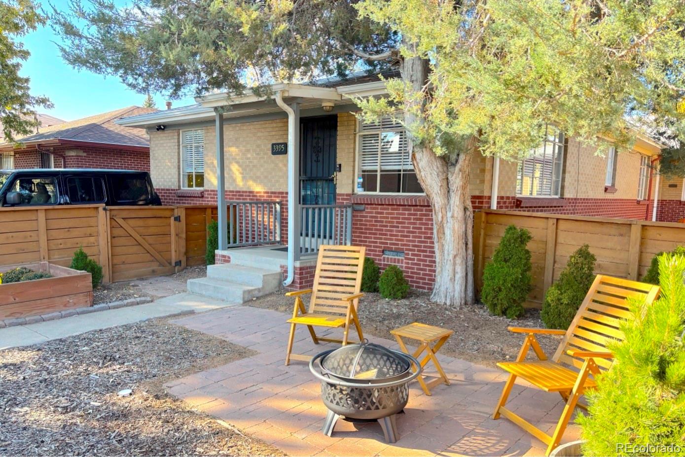 a view of a patio with table and chairs and wooden fence