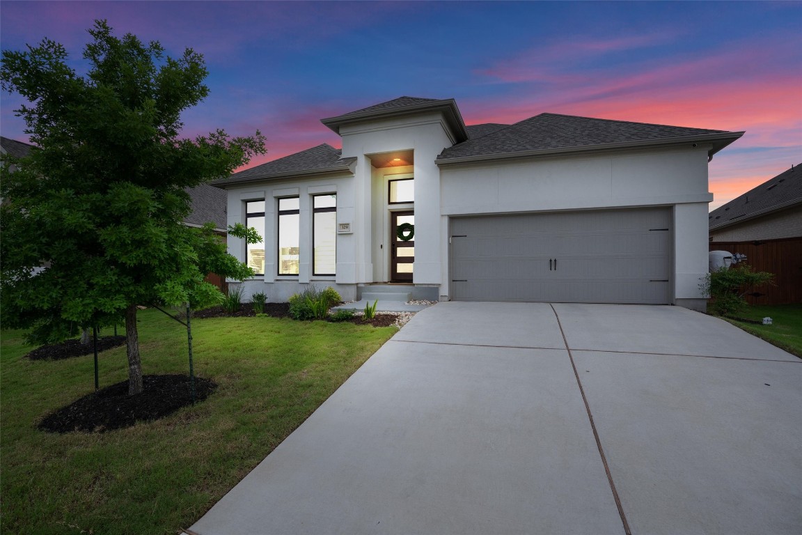 a front view of a house with a yard and garage