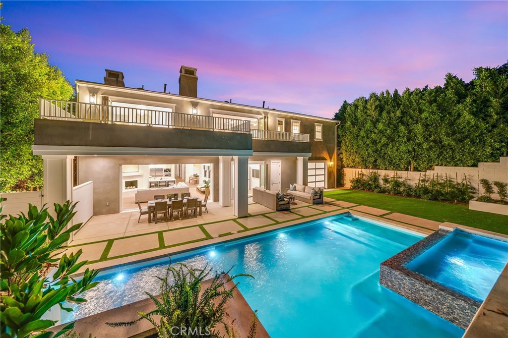 a view of a house with swimming pool lawn chairs and a yard