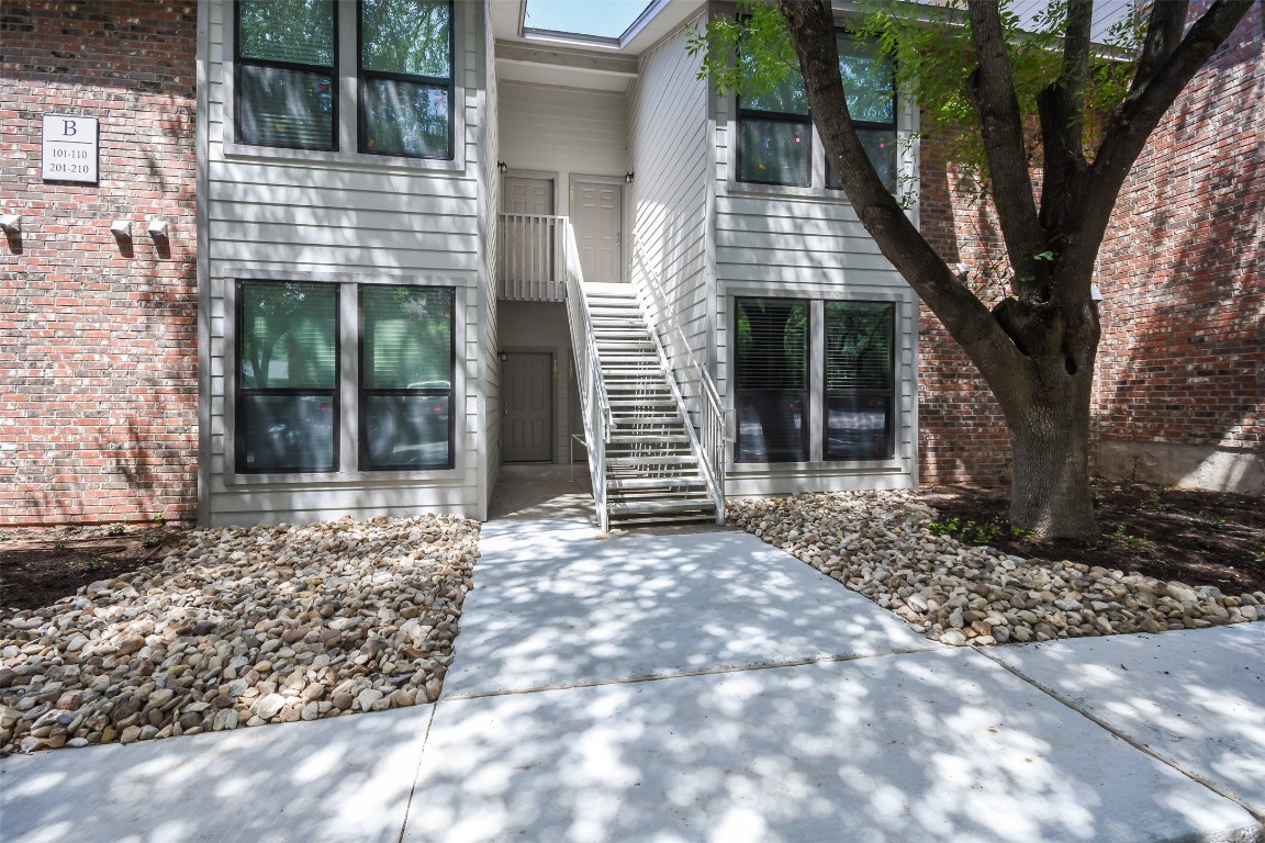 a front view of a house with a tree