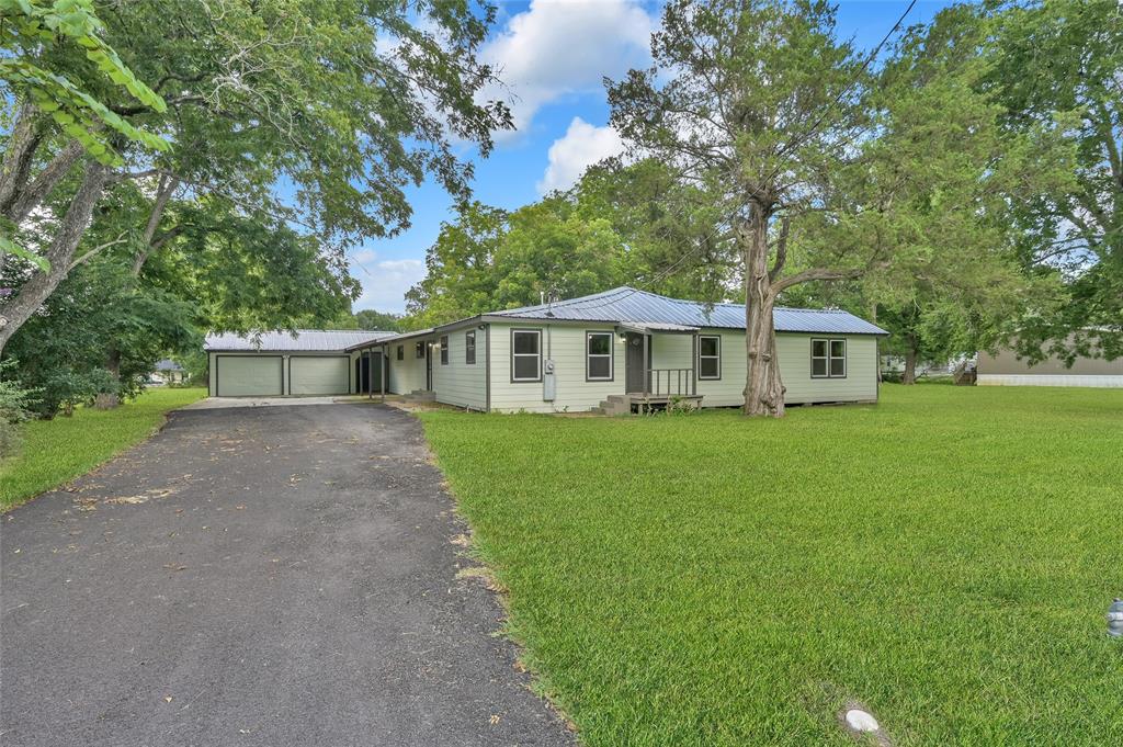 a front view of a house with a yard and trees