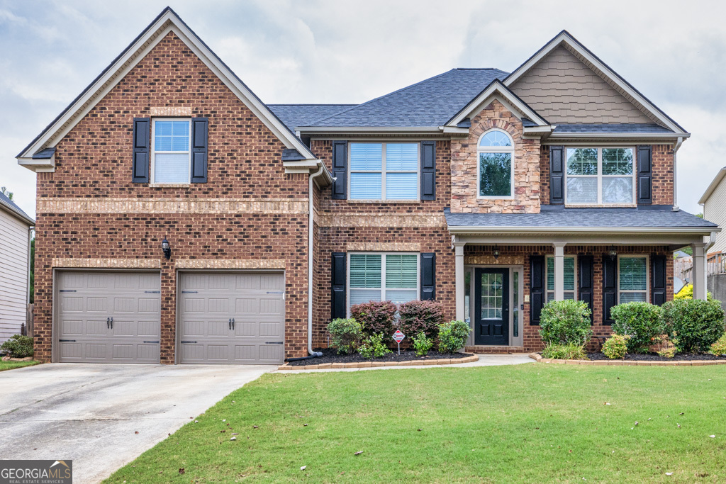 a front view of a house with a yard and garage