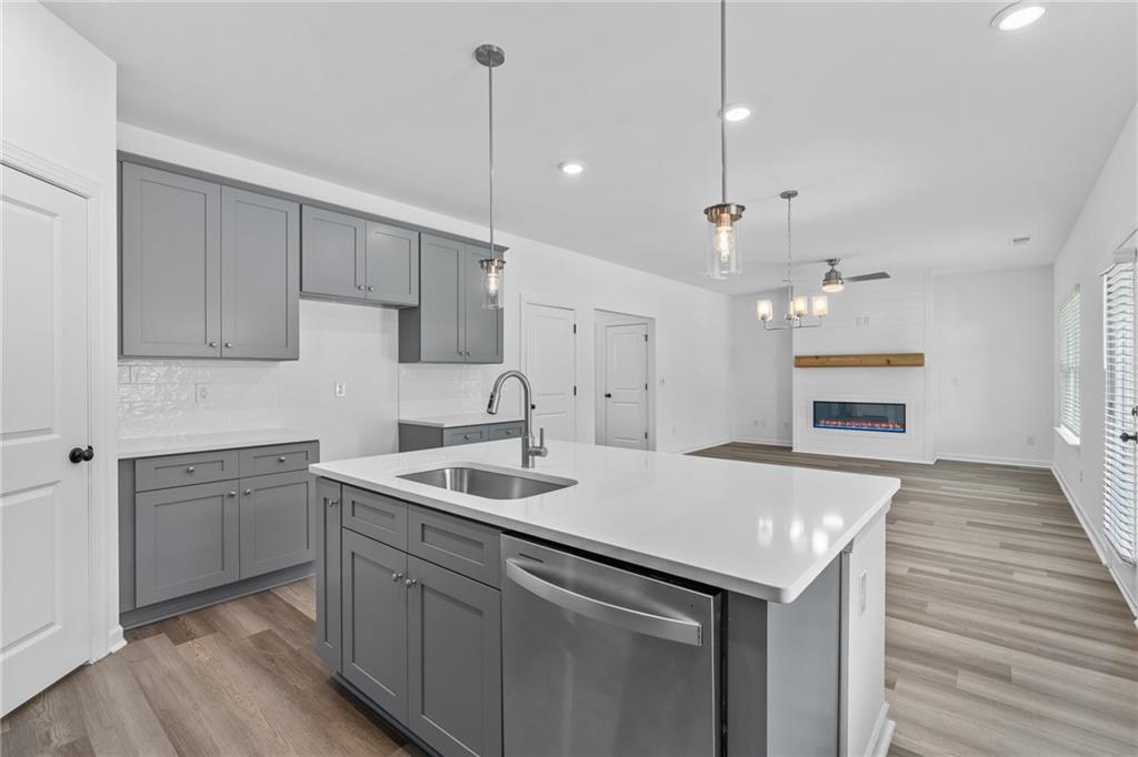 a kitchen with a sink dishwasher a stove and a refrigerator with wooden floor