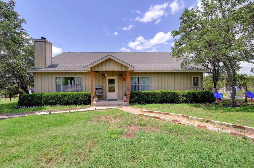 a front view of a house with a yard and trees