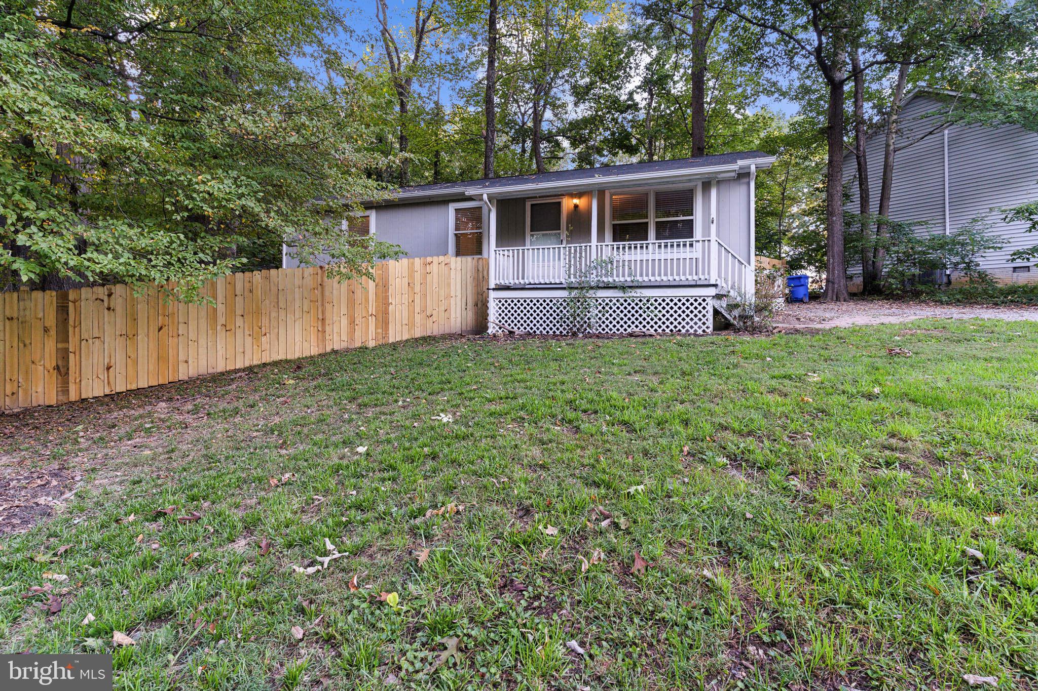 a front view of house with yard and trees around