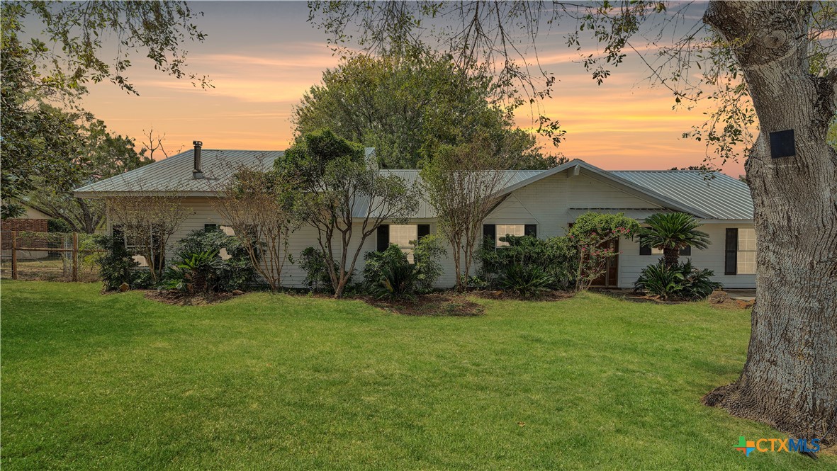 a view of a house with a yard and tree s