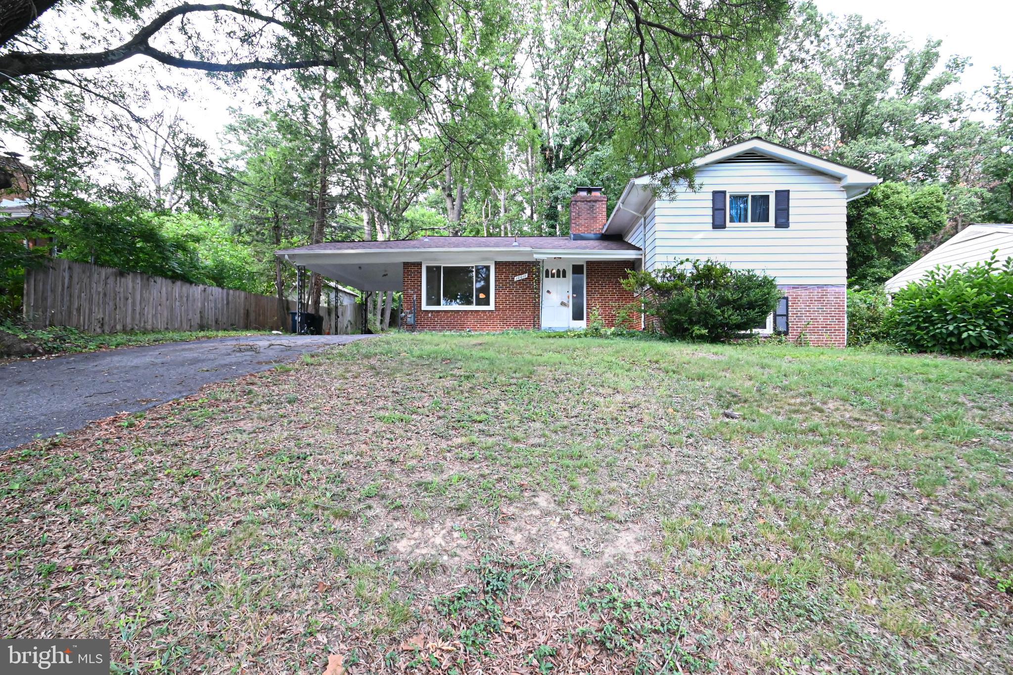 a front view of a house with a yard and trees