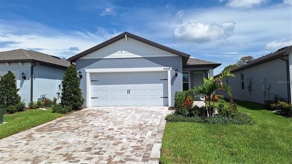 a front view of a house with a yard and garage