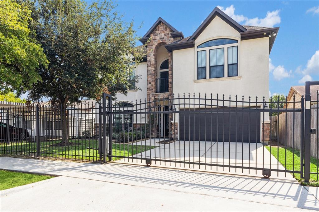 a view of a house with a small yard and wooden fence