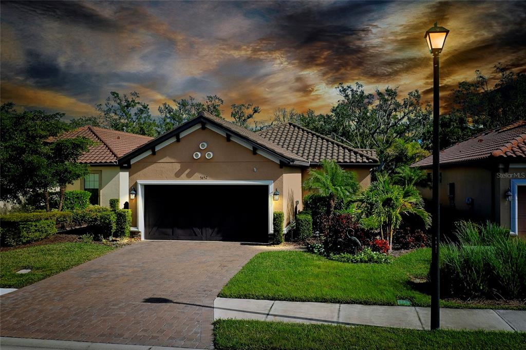 a front view of a house with a garden and plants