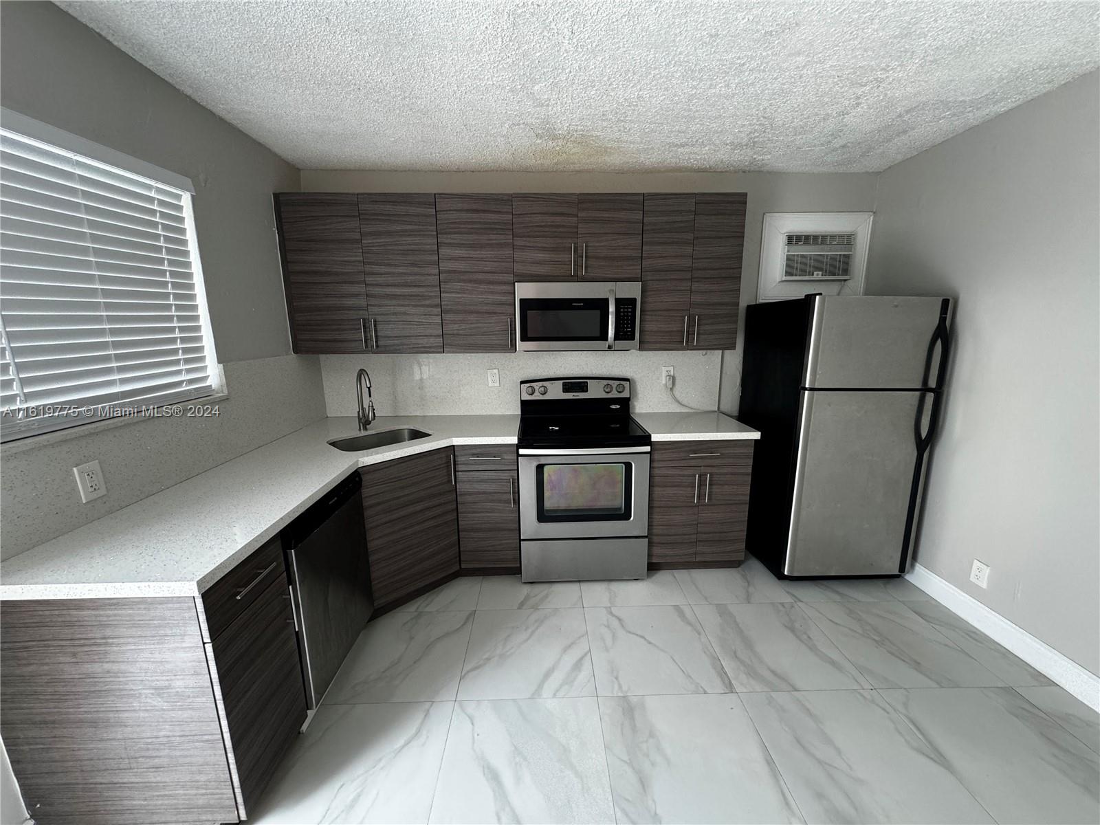 a kitchen with a refrigerator sink and wooden cabinets