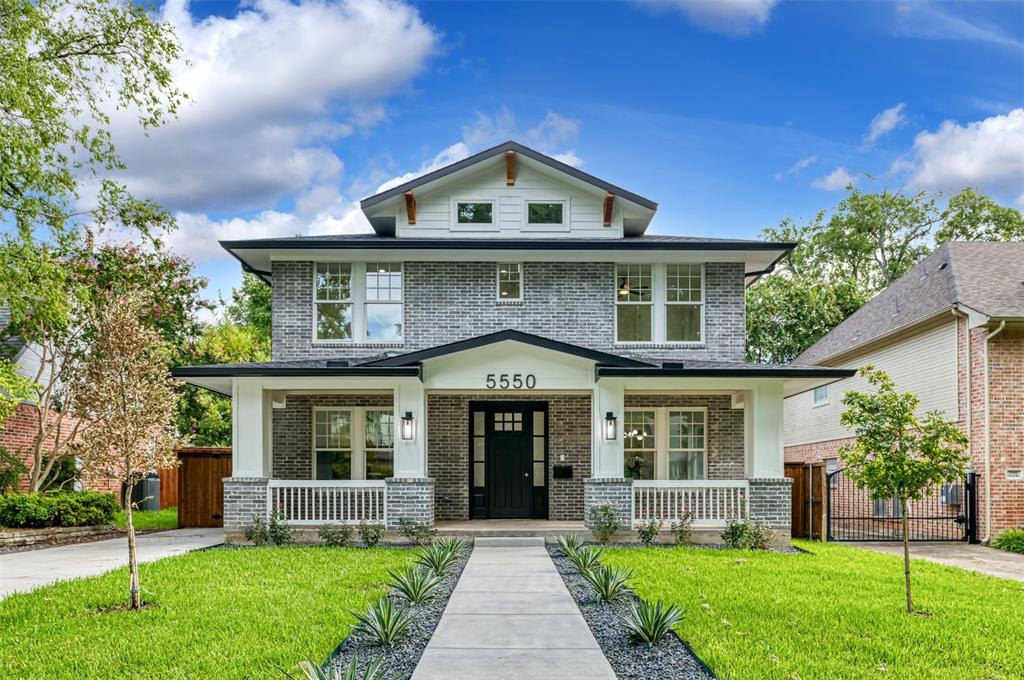 a front view of a house with a yard and potted plants