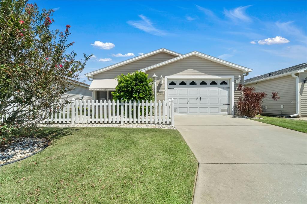 a view of a house with a yard and fence