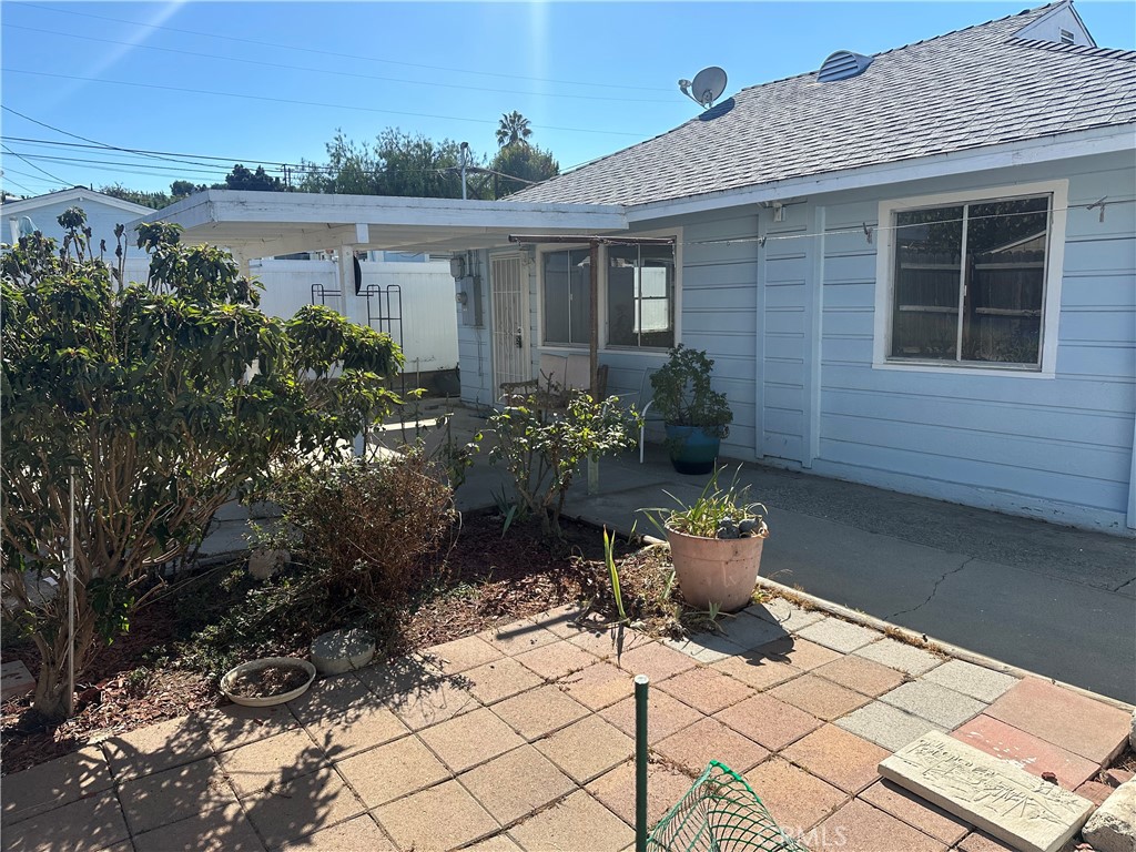 a view of a backyard with chair potted plants