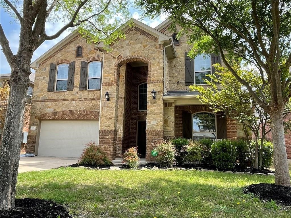 a front view of a house with a yard and garage