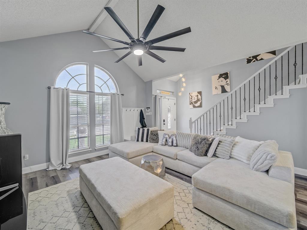 a living room with furniture a large window and a chandelier