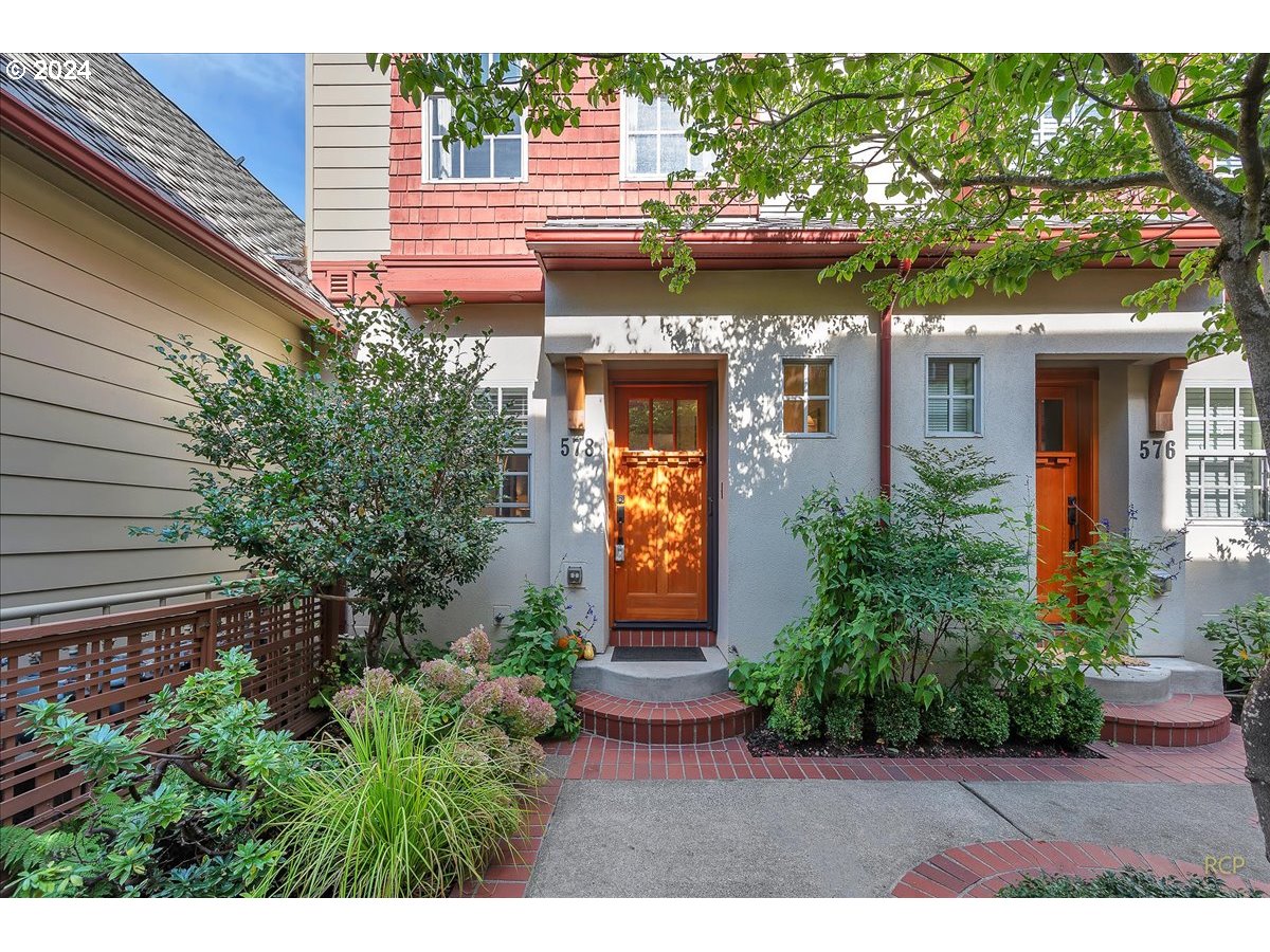 a view of a house with brick walls and potted plants