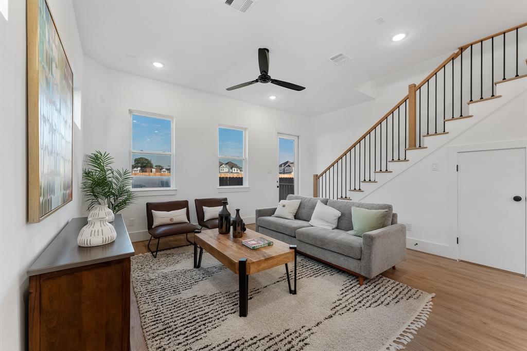 a living room with furniture and a wooden floor