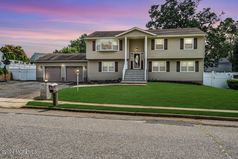 a front view of a house with a garden and yard