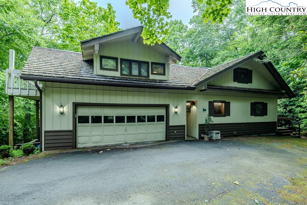 a view of house with a yard and large tree