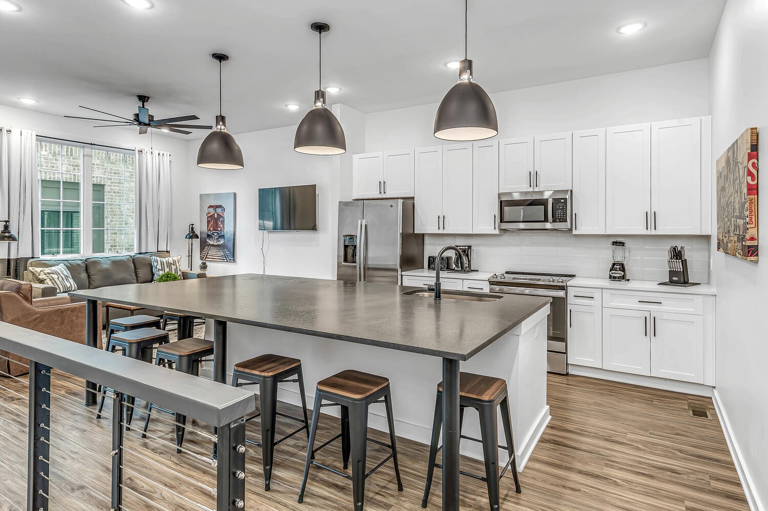 a kitchen with stainless steel appliances granite countertop a sink a stove and a wooden floors