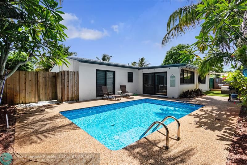 a view of a house with swimming pool and sitting area