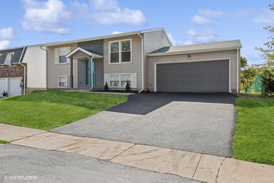 a front view of a house with a yard and garage