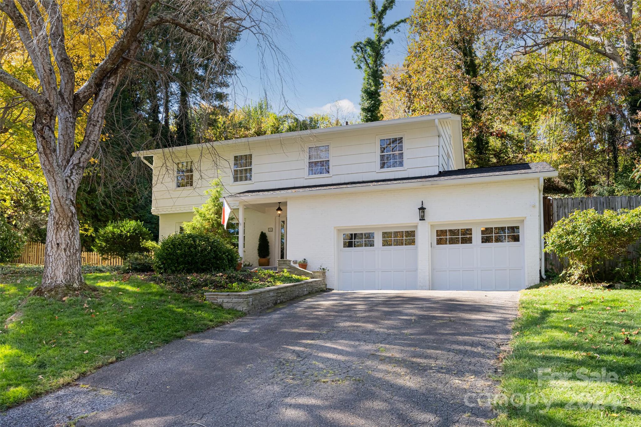 a front view of a house with a yard and trees