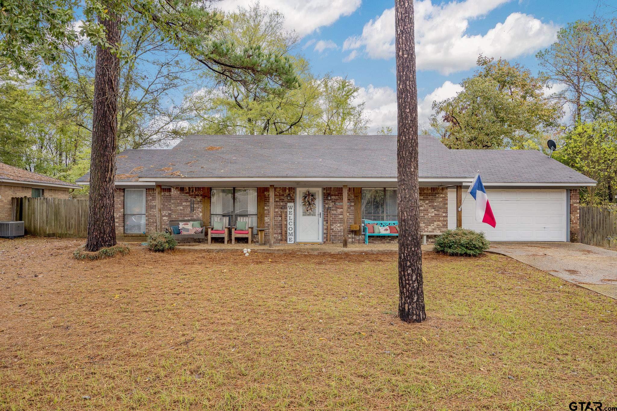 a front view of a house with a porch and a yard