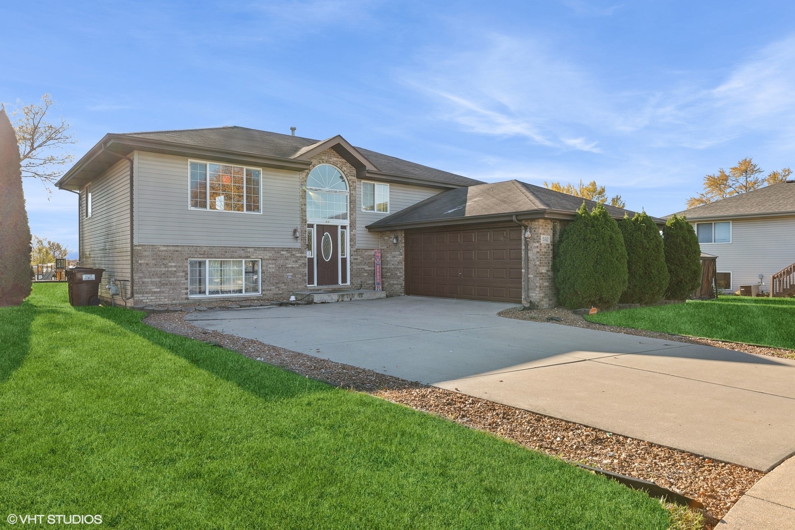 a front view of a house with a garden and yard