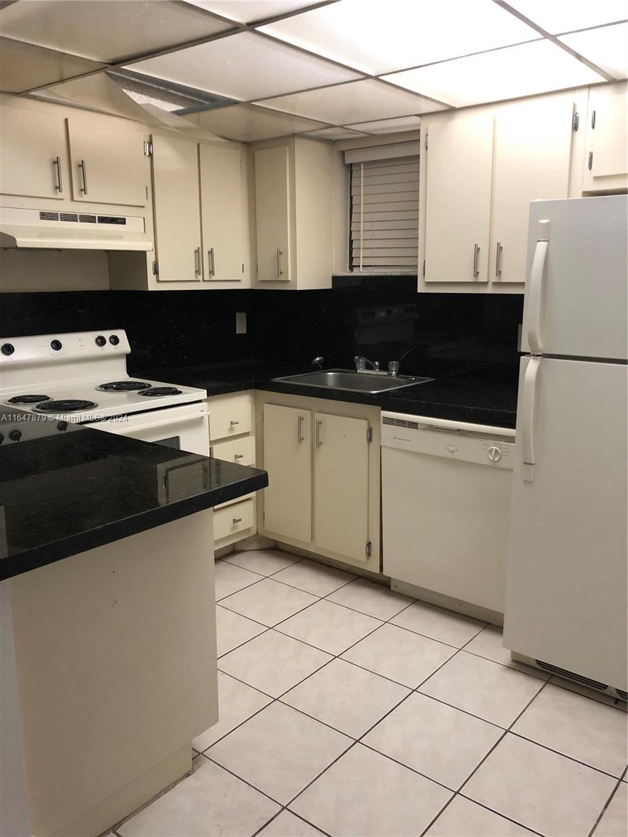 a kitchen with a sink and a refrigerator